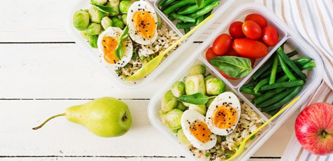 bento box met gekookte eieren, spruitjes, sperziebonen, rijst en tomaten